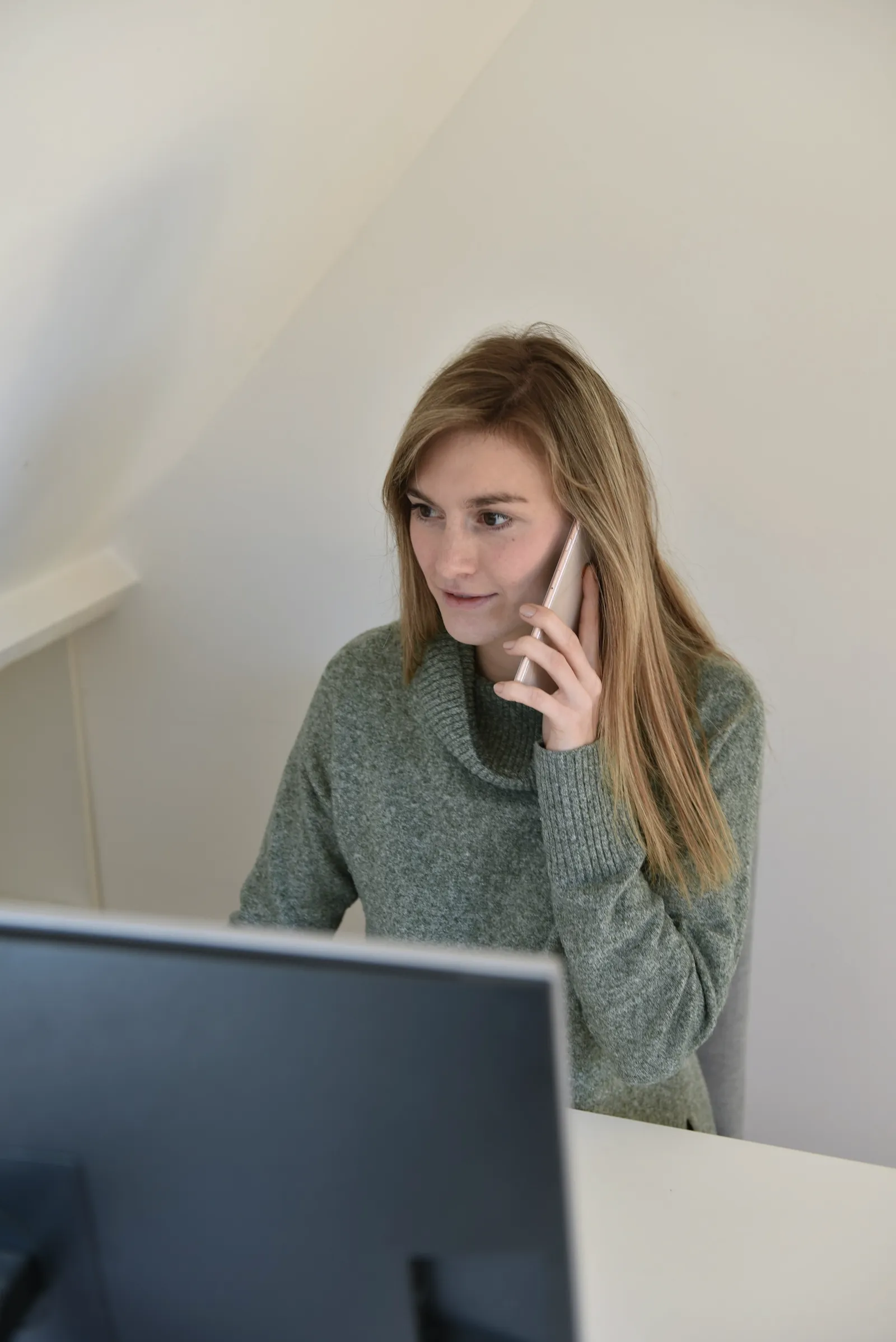 A woman on a phone call at her desk.