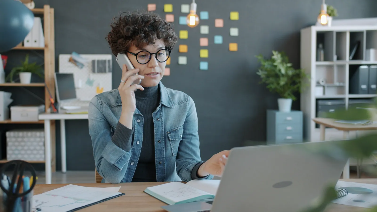 A woman on a phone call in an office.